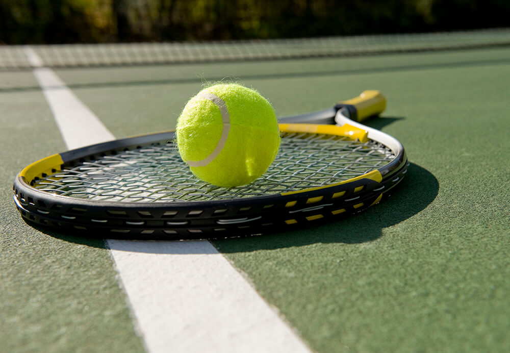 tennis ball and racquet on court